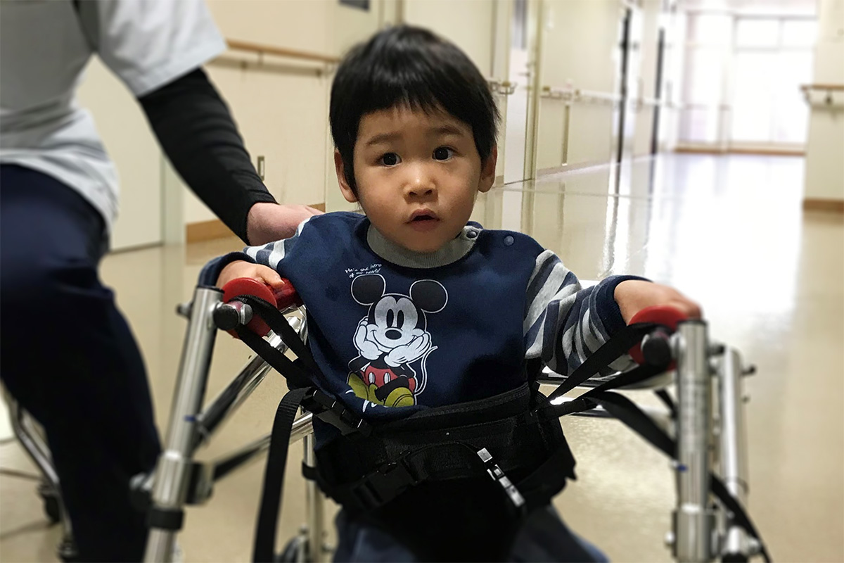 歩行器で移動する子ども